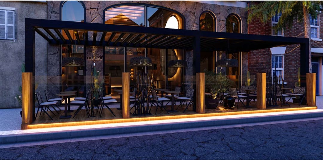 Glazed terrace of a venue with a pergola, lit at night